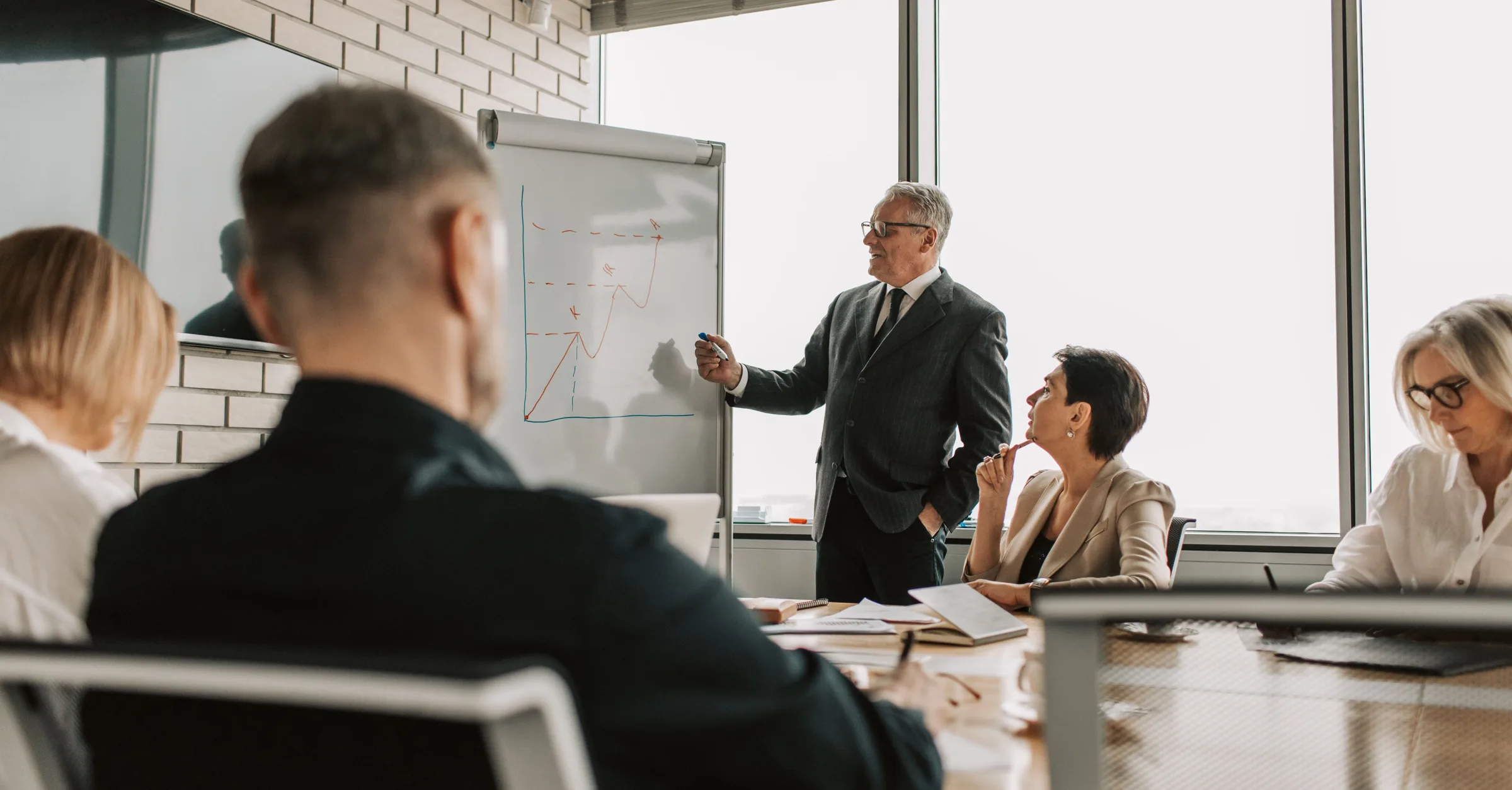 A consultant presenting growth charts to colleagues in a meeting room